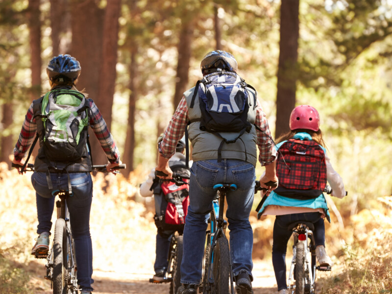 A family biking on a community bike path through the woods