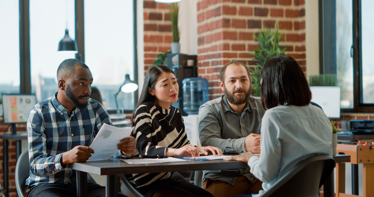 three employers sitting together and lecturing an employee