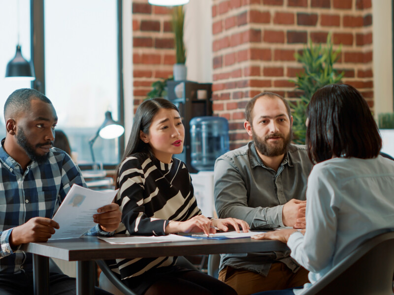 three employers sitting together and lecturing an employee